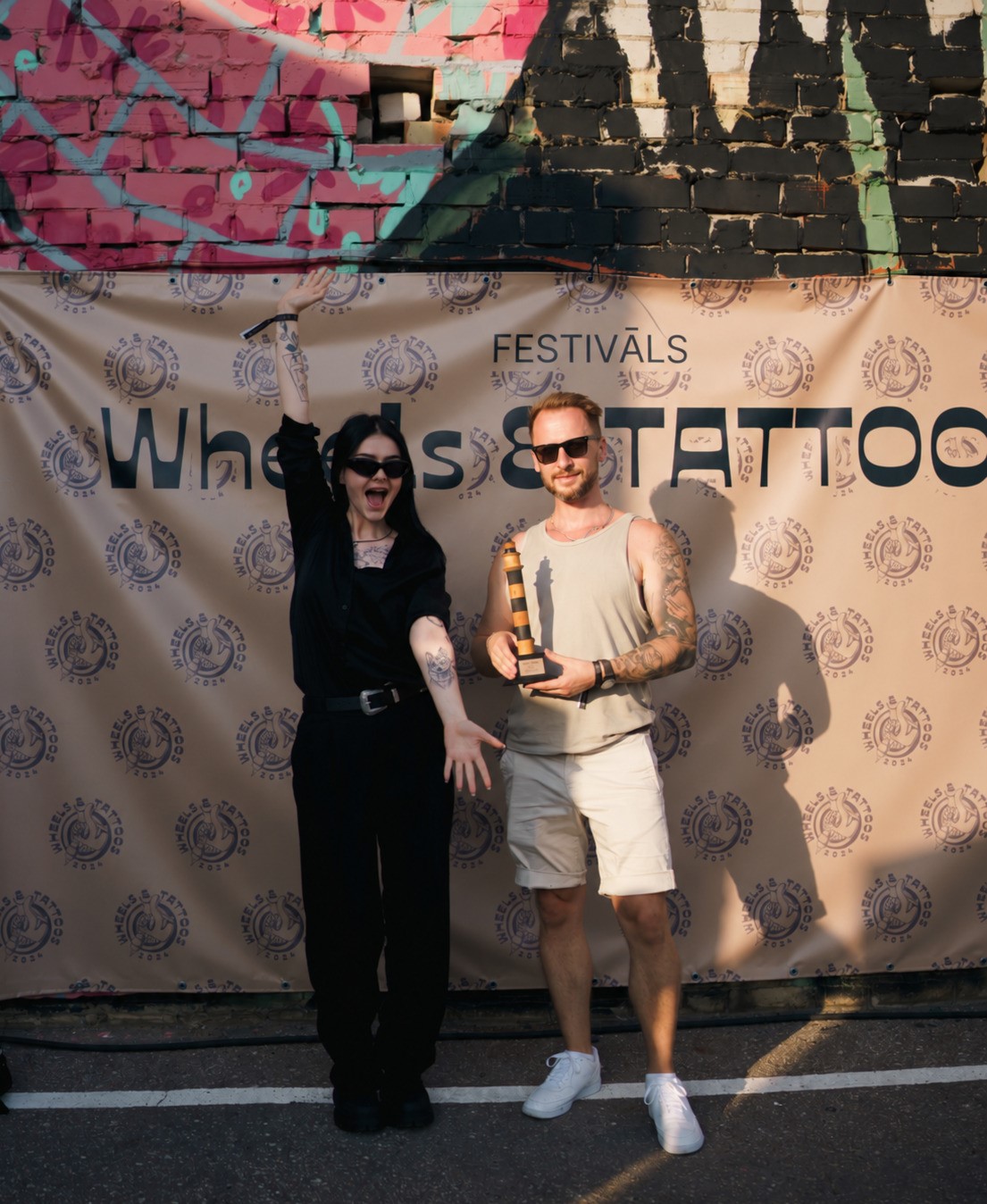 Ritvars Gruntiņš ar modeli pēc uzvaras Wheels & Tattoos 2024 tetovēšanas konvencijā